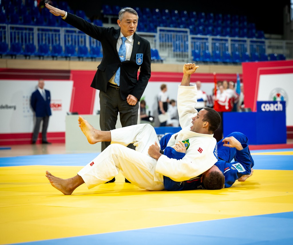 Arthur cai sobre o francês Cyril Jonard já com o punho direito em sinal de comemoração enquanto o árbitro da luta faz o comando do ippon Ralf Kuckuck/DBS.